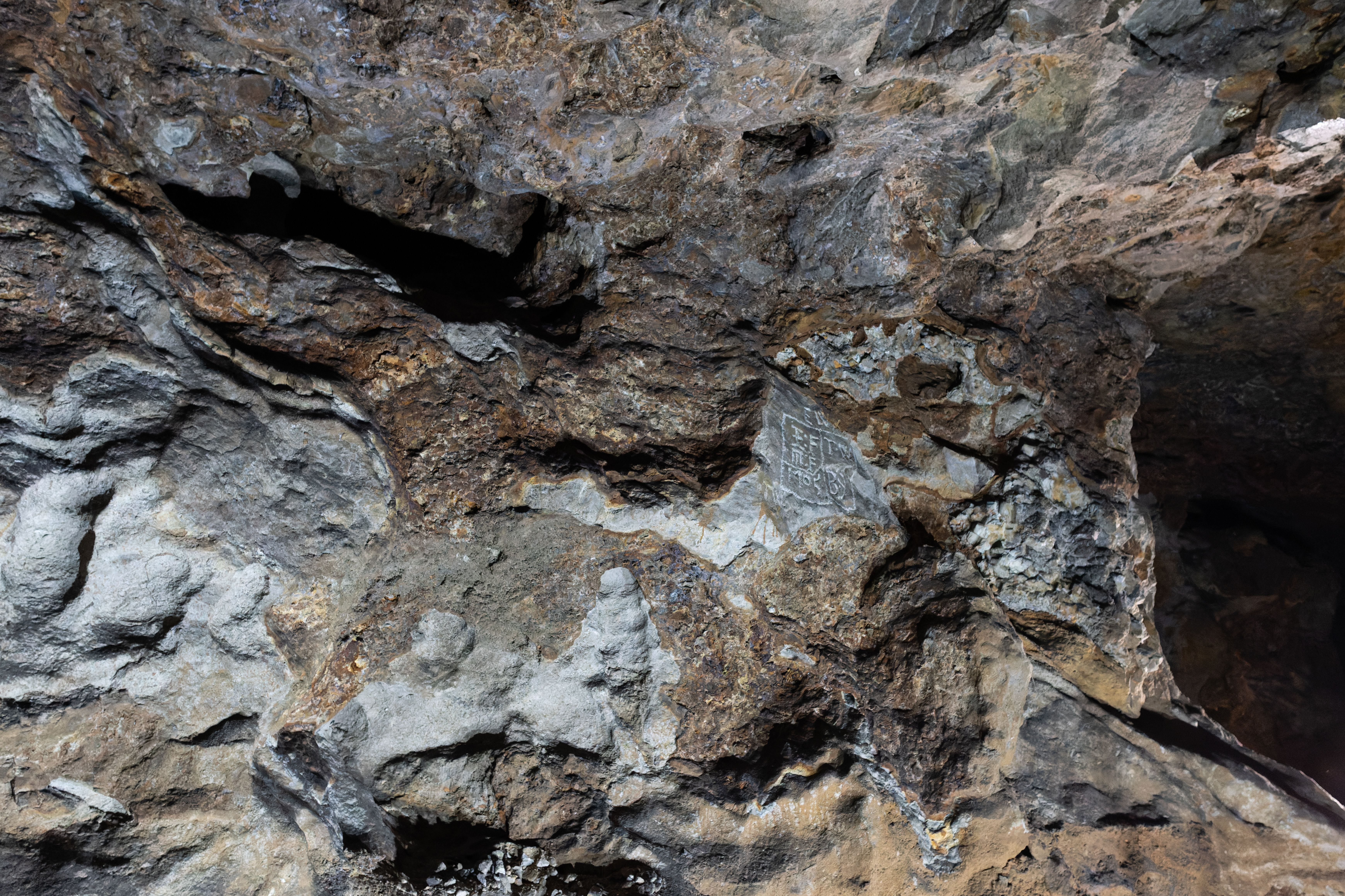 A wall of the limestone cave where lead miners etched in their markings